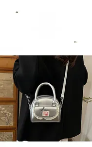 Detail of silver shell bag with lace trim, checkered bow, and red bunny patch details