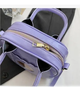 Detail view of the smooth golden metal zipper and purple glossy patent leather finish