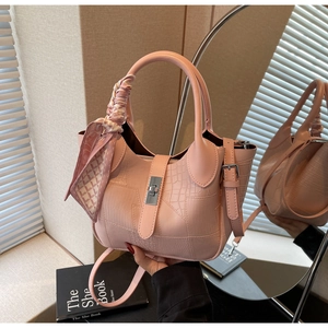 Detail of pink PU handbag featuring embossed crocodile texture and silver turn-lock clasp