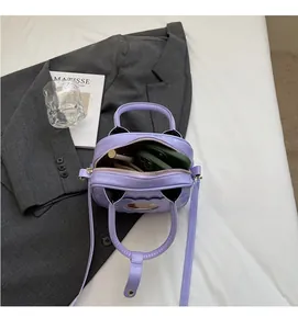 Detail view of the spacious inner compartment of the purple patent leather handbag