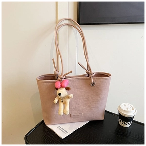 Close-up of pink tote bag with pebble leather texture and cute puppy plush charm