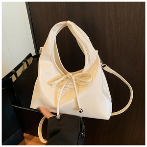 Detail of cream white leather hobo bag with bow drawstring and silver metal beads