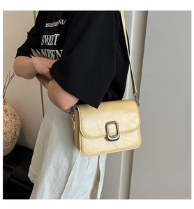 Chic cream small square bag with silver clasp and adjustable shoulder strap on model