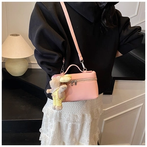 Pink lychee grain leather box bag styled with a cute rabbit charm on a female model