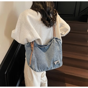 Detail of vintage denim tote bag showing rugged texture and handcrafted rope handle