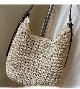 Dettaglio della borsa hobo in paglia intrecciata con tracolla in pelle marrone regolabile