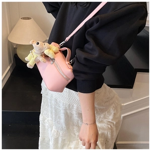 Pink pebbled leather box bag with cute plush bear charm worn with casual streetwear