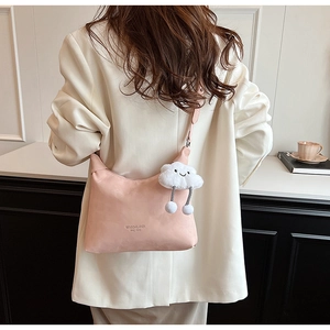 Pink PU leather crossbody bag with cloud charm shown on model in white blazer