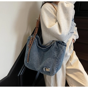 Detail view of the durable denim tote bag with unique brown woven rope shoulder straps
