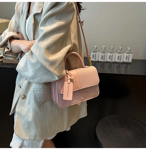 Detail of contrast color crossbody bag with textured mesh stitching and leather finish