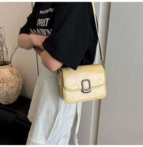 Detail of light yellow square crossbody bag with large matte silver square twist lock