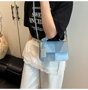 Detail of sky blue crossbody bag featuring mixed textures and golden hardware accents