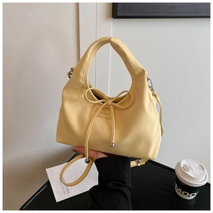 Close-up of a creamy yellow Boston bag featuring a drawstring bow and NO FILTER text
