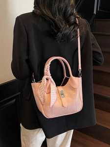 Pink stone pattern bucket bag with silk scarf on handle worn by model on stairs