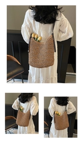 Dettaglio di una borsa a spalla in paglia intrecciata con spalline in pelle su modella