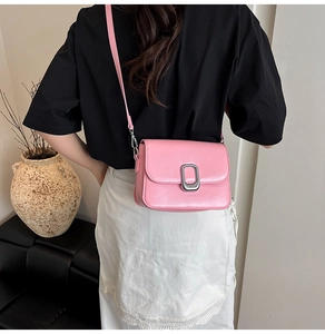 Pink PU leather crossbody bag with silver metal lock shown on a model's back