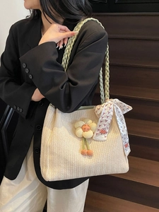 Borsa tote estiva in paglia intrecciata con ciondolo a fiore e foulard su scala di legno