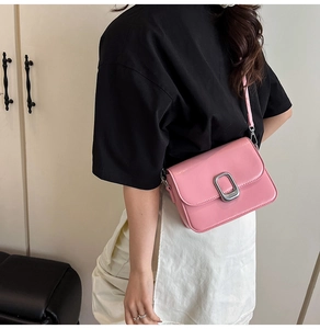 Detail of pink glossy patent leather crossbody bag with elegant silver square buckle