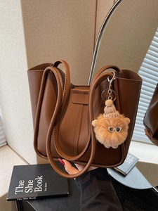 Minimalist brown matte leather tote bag with stylish plush pendant for daily commute
