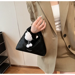 Detail of black PU leather half-moon bag with silver logo and white plush cloud charm