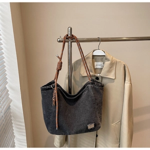 Charcoal denim tote bag detail featuring brown braided rope strap on silver hanger