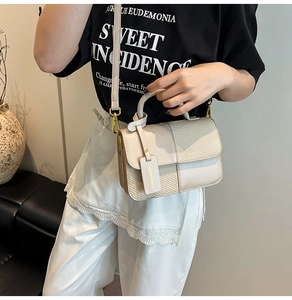 Detail of beige contrast handbag featuring smooth faux leather and woven texture panels