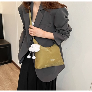 Detail of olive green PU leather bag with white brand text and plush cloud charm