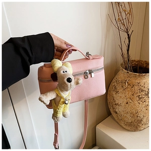 Pink lychee grain box bag with top handle and cute cartoon puppy pendant detail