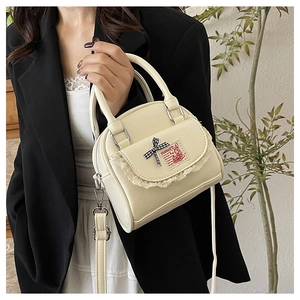 Detailed view of cream PU leather handbag with lace trim and check bow accent