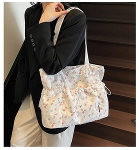 Detail of floral tote bag with pleated texture, drawstring closure, and functional pockets