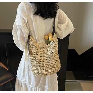Dettaglio della borsa hobo in paglia intrecciata con tracolla in pelle marrone