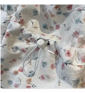 Detail of floral lace embroidery and adjustable drawstring closure on the tote bag