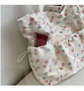Detail of floral lace tote bag featuring a practical side drawstring pocket for storage