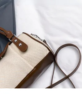 Nahaufnahme der braunen Leder- und beigen Webstofftasche mit silbernen Nietendetails