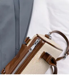 Nahaufnahme des silbernen Metallreißverschlusses und der Lederpaspel an der Zylindertasche