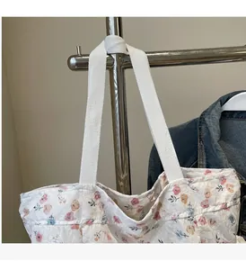 Detail of floral print tote bag with soft fabric texture and wide fabric handles