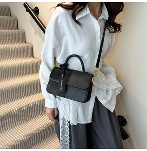 Detail showing high-quality PU leather stitching texture and golden metal lock of the handbag