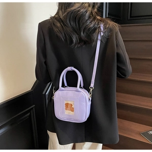 Detail of purple glossy PU leather crossbody bag with cute cartoon card slot