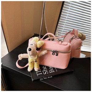 Pink lychee texture box bag with silver zipper and cute plush dog charm detail