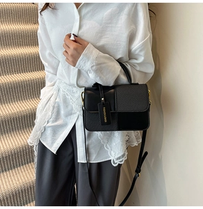 Close-up of contrast crossbody bag featuring houndstooth texture and leather details
