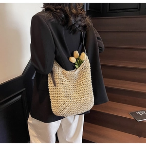 Dettaglio della borsa hobo in paglia intrecciata a mano con tracolla in pelle
