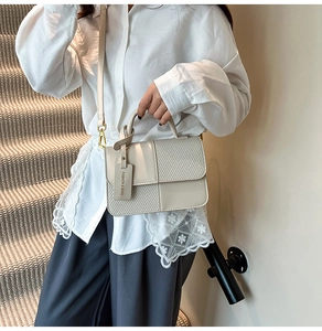 Close-up of contrast square handbag with textured weave panels and fashion tag