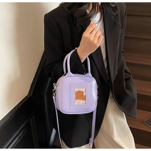 Detail of light purple glossy small square bag with card window shown on wood stairs