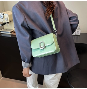 Detail of pistachio green leather crossbody bag with silver rectangle buckle closure