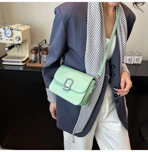 Minimalist mint green crossbody square bag with metallic buckle shown on a model