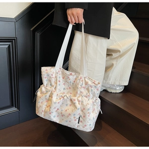 Detailed close-up of a floral tote bag with front drawstring pockets and canvas fabric