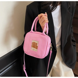 Detail of pink glossy patent leather handbag featuring a cute cartoon dog card slot