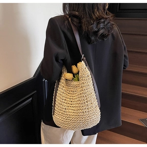 Vista dettagliata della borsa tote in paglia fatta a mano con spalline in pelle marrone