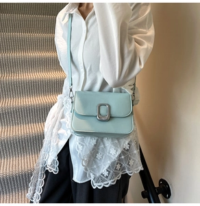 Detail showing smooth light blue faux leather texture and silver rectangular buckle