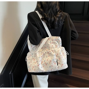 Detail of floral canvas tote bag with drawstring closure and white woven handles
